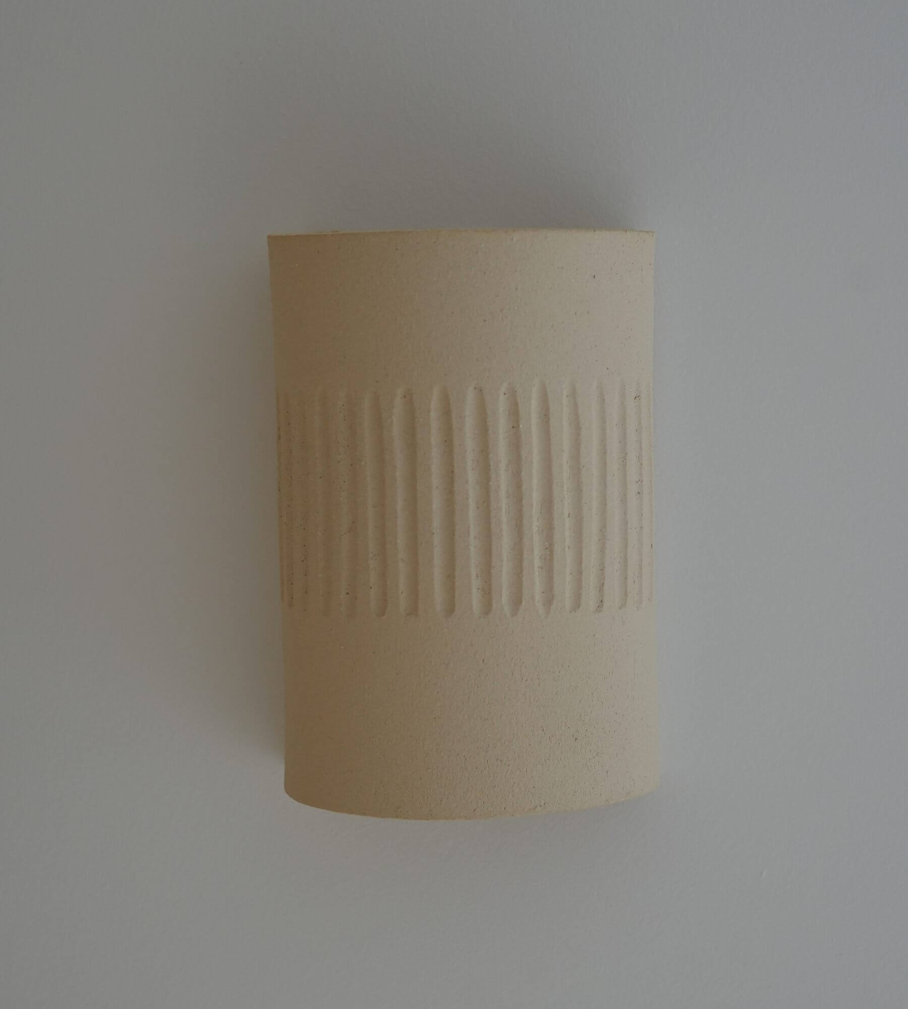 Applique céramique artisanale sur fond mur blanc 